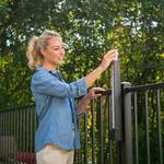 Woman Entering Garden Secured with Locinox FortiMa Pool Safe Gate Latch
