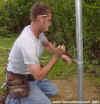 Chain link tension wire is looped through the nut and bolt of a brace band.
